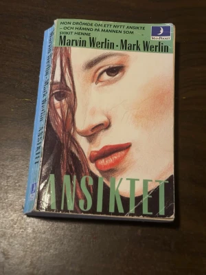Ansiktet av Marvin & Mark Werlin - En pocketbok med titeln 'Ansiktet' av Marvin Werlin och Mark Werlin. Omslaget har en tecknad närbild av ett kvinnligt ansikte med röda läppar och brunt hår. Boken är utgiven av Månpocket och har en mintgrön baksida med svart text.