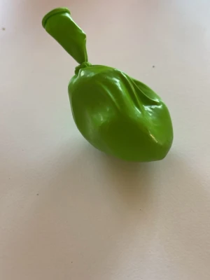 Grön stressboll av ballong - En grön stressboll gjord av en ballong fylld med socker. Perfekt att klämma på när du behöver slappnas av eller fokusera. Ballongen är knuten i toppen och har en flexibel form som anpassar sig efter handen.