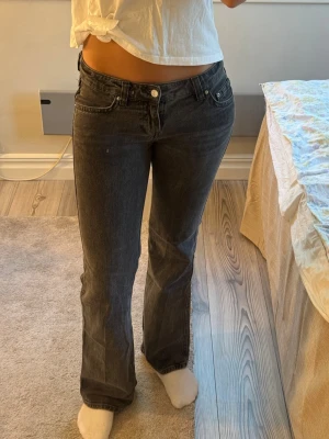Mörkgrå bootcut jeans med fickdetaljer - Snygga mörkgrå jeans med bootcut passform och coola fickdetaljer bak. Jeansen har klassisk femficksdesign framtill. 
