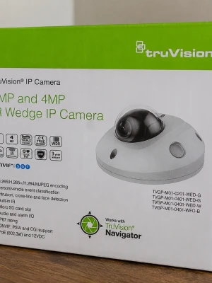TruVision IP Domekamera - Säljer en TruVision IP domekamera med rund, vit design och svart kupol. Kameran har stöd för 2MP och 4MP upplösning, inbyggd IR, rörelsedetektering och micro SD-kortplats. Perfekt för övervakning och enkel att montera i tak eller på vägg.