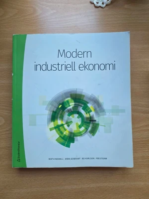 Modern industriell ekonomi bok - Kurslitteratur med titeln 'Modern industriell ekonomi'. Omslaget är vitt med gröna och gråa grafiska mönster samt en grön rygg. Perfekt för dig som pluggar industriell ekonomi eller liknande ämnen.