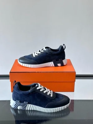 Marinblå sneakers med vit sula - Snygga marinblå sneakers med ovandel i mocka och läderdetaljer. Skorna har vita snören och en chunky, räfflad vit sula med svarta detaljer på sidan och undersidan. Modern design med coola kontraster och dragflik bak.