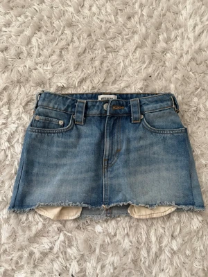  jeanskjol från Weekday - Blå jeans från weekday, satt på egen extra knapp, bra om den är för tajt eller för stor. Liten i storleken. Tyget är mycket tvättat och därför strävt🥰