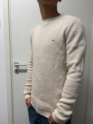 Stickad Hilfiger tröja  - Snygg beige stickad tröja från Tommy Hilfiger i storlek S. Bra skick. Modellen är 173cm, 64kg. Pris kan diskuteras!!