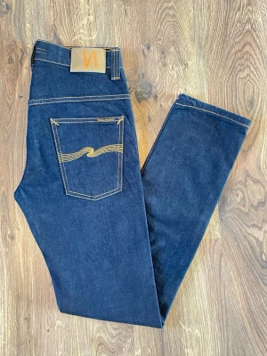 Nudie jeans - Säljer ett par riktigt snygga Nudie Jeans Tape Ted i färgen org. 16 drips dry. 👖🔵 Stilren och lättmatchad färg som passar perfekt till både vardag och lite finare outfits. Jeansen är i 10/10 skick och storlek W31 L34. En riktigt snygg modell med en modern passform som sitter riktigt bra. Pris: 499 kr. Skriv gärna vid minsta fundering! 😊