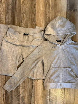 grå mjukisdress från juicy couture  - mjukisdress från juicy couture i grått. bra skick förutom att dragkedjan på koftan saknar ”J” symbolen samt band till mjukisbyxorna finns ej, se bilder 😇