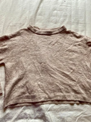 Beige stickad tröja från 157 - Mysig beige stickad tröja från 157 i storlek S. Tröjan har en enkel, rak passform med ribbstickad halsringning och mjukt material som känns skönt mot huden. Perfekt för lager på lager och en avslappnad look.