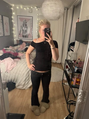 Svart offshoulder topp - Säljer en svart offshoulder topp med tight passform. Toppen är ärmlös på ena sidan och har en axelbandslös design på andra sidan, vilket ger en trendig look. Perfekt att styla med jeans eller kjol för en cool outfit.
