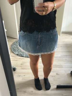 Kort jeanskjol med spetskant - Säljer en blå kort jeanskjol med vit spetskant längst ner. Kjolen har klassiska fickor fram och bak samt en snygg, avslappnad passform. Perfekt för dig som vill ha en söt och enkel denimlook.Har även gjort om denna kjolen, detta var en lång kjol som jag kortade ner lite och sydde på spets💕