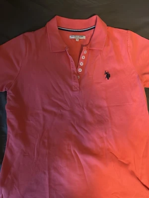 Rosa pikétröja från US Polo Assn - Rosa pikétröja från US Polo Assn  Klassisk krage med knappar och broderad logga.