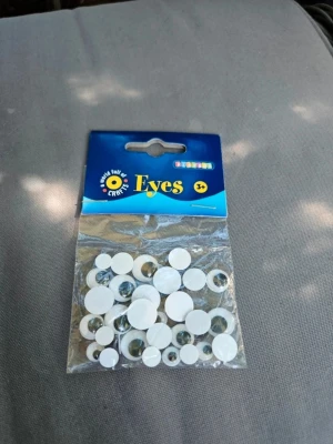 Påse med rullande pysselögon - Säljer en oöppnad påse med rullande pysselögon i olika storlekar. Perfekt till DIY-projekt, scrapbooking eller dekoration. Ögonen är vita med svart pupill och kommer i plastförpackning. Passar för dig som gillar att pyssla och skapa egna figurer.