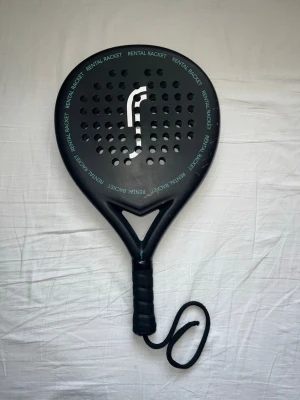 Svart padelracket - Säljer ett padelracket i bra skick. Racketen är fullt fungerande och passar perfekt för både nybörjare och motionärer. Den har normala ytliga användningsspår, men inga sprickor eller skador som påverkar spelet. Finns att hämta i Södertälje.