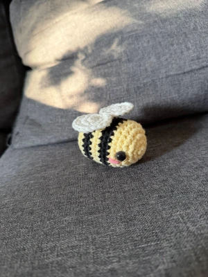 Virkat bi - Sött handvirkad bi i bomullsgarn.🐝 ⚠️Säkerhetsögon därför rekommenderas den inte till barn under 3 år.⚠️Perfekt som liten present eller dekoration. Måttet är ca 7x5cm. Det finns 3 till. Vill du ha mer än denna så skriv så ordnas det. Då de är handgjorda kan jag inte lova att alla ser likadana ut.