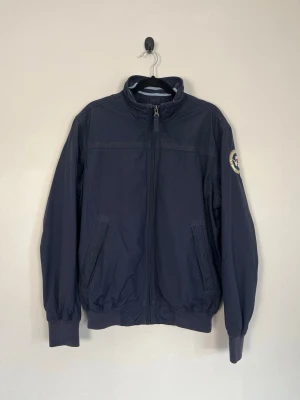 Napapijri Expedition Vintage Jacka Navy Bomber Windbreaker Storlek SNapapijri Expedition Vintage Jacka Navy Bomber Windbreaker Storlek S - • Storlek: S • Färg: Marinblå  • Passform: Regular Fit  • Krage: Hög ståkrage • Material: Yttertyg 100 % polyamid och foder 100 % polyester   Skick: Plagget är i väldigt fint skick. Eventuella anmärkningar anges alltid tydligt i beskrivningen och visas på bilderna.  Nypris: Cirka 2 700 kr.  📦 Skickas snabbt och packas omsorgsfullt. 💬 Hör gärna av dig om du har frågor eller vill se fler bilder. 🤝 Samfrakt erbjuds vid köp av flera plagg – kika gärna in mina andra annonser!
