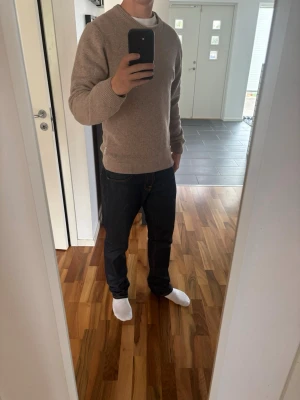 Causal friday Beige stickad tröja  - Säljer en stilren beige stickad tröja med rund hals och ribbade muddar vid ärmslut och nederkant. Tröjan har en enkel och klassisk design som passar perfekt till jeans eller chinos. Materialet känns mjukt och bekvämt mot huden.