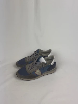 Philippe Model Sneakers - 🌸 INFO OM PLAGGET 🌸  ☑️ Märke: Philippe Model ☑️ Storlek: 42 ☑️ Färg: Blå-Grå ☑️ Skick: ⭐⭐⭐⭐  ✨ Detaljer: ☐ Inga hål ☐ Inga fläckar ☐ Rökfritt hem ☐ Djurfritt hem  📏 Passform: ☑️ Normal   📦 Skickas snabbt. 💬 Skriv gärna om du vill ha fler bilder eller mått. 🤍 Paketrabatt vid köp av flera annonser. 🌟 Titta gärna på mina andra annonser!