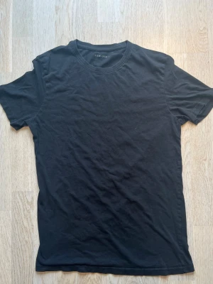Svart basic t-shirt från Pier One - En enkel svart t-shirt från Pier One med rund hals och korta ärmar. Tillverkad i mjuk bomull som känns skön mot huden. Perfekt att matcha med jeans eller shorts för en clean och stilren look. Tveka inte på att skriva en fråga eller be om fler bilder.🌸🌸