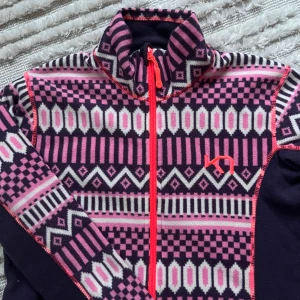 Mönstrad fleecejacka från Kari Traa - Säljer den otroligt snygga och sköna fleecejackan från Kari Traa 💕Jackan har ett färgstarkt mönster i rosa, lila och vitt med orange dragkedja och logga. Långärmad med hög krage och mjukt fleecematerial, perfekt för kyliga dagar 🫶🏼 Använd ett fåtal gånger och inga tecken på användning. Storlek M men passar även XS och S! Nypris 300 kr