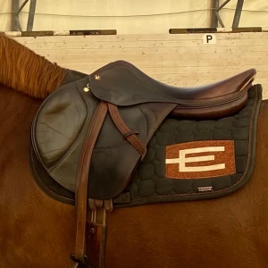 Equiline schabrak  - Snygg Equiline schabrak i svart med brons E-logga. Schabraket är i gott skick använt det på min maxade C-ponny.