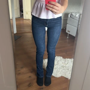 Mörkblå bootcut jeans med hög midja - Snygga mörkblå jeans med bootcut och hög midja. Klassisk femficksmodell med kontrastsömmar och dragkedja fram. Jeansen sitter tight över låren och har lätt utsvängda ben. Perfekta för dig som gillar en tidlös och cool look. Skit snygga sitter så fint runt midjan och formas efter kroppen🥰 De är stretchiga och jag gillar väldigt mycket men de jeansen kommer inte till användning. SÄLJS ändas därför ‼️☺️ Använt 2 gånger 🥰