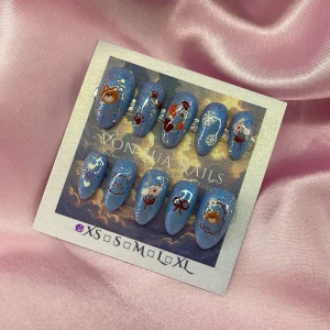 BlueBear (XS);Short Almond;Curved - Set med handgjorda press-on naglar i blått med glitter och motiv som björnar, blommor, rosetter, hjärtan och snöflingor. Naglarna har en kort mandelformad design och kommer i XS: 14 mm, 11 mm, 11,5 mm, 10 mm, 8 mm. Perfekt för dig som vill ha unika och gulliga naglar utan att gå till salong.