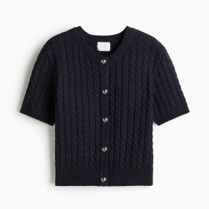 Mörkblå stickad kofta med kort ärm - Snygg mörkblå stickad kofta med korta ärmar och rund hals. Koftan har ett klassiskt kabelstickat mönster och silverfärgade knappar framtill. Perfekt för dig som gillar en classy look.