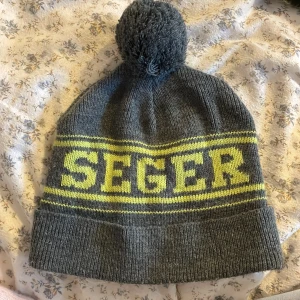Grå SEGER mössa med tofs - Snygg grå stickad mössa från SEGER. Fint skick