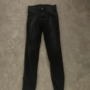 Svarta Replay anbass hyperflex - Svarta jeans från Replay med slim fit och klassisk femficksdesign. Jeansen har en mörk tvätt med lätt slitning och Replay-logga på myntfickan. Passar dig som gillar en smal siluett och stilren look. Materialet är mjukt och stretchigt jeans.
