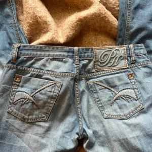 Ljusblå jeans från Pepe Jeans - Säljer ett par ljusblå jeans från Pepe Jeans med snygga detaljer på bakfickorna och ett broderat logomärke på linningen. Klassisk femficksmodell med raka ben och normal passform. Jeansen har slitningar framtill för en cool look. Jag köpte dessa av en tjej på plick❤️||  Mått: Midja:86cm (hela midjemått) Lår: 100cm (hela omkrets) Storlek: 29/38/M ||