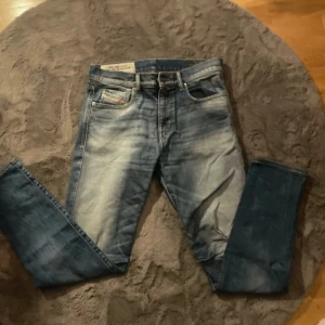 Blå Diesel D-Strukt jeans slim fit - Snygga blå jeans från Diesel, modell D-Strukt med slim passform. Jeansen har klassisk femficksdesign, diskret Diesel logga på bakfickan och fet tvätt framtill. Tillverkade i stretchig denim med italiensk design för extra komfort.