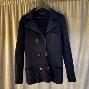 Mörkblå stickad cardigan - Tja säljer en snygg mörkblå kofta från Carine.(Made in paris) Perfekt för dig som gillar klassisk stil. Perfekt nu till hösten/vintern. Skulle säga att den sitter som en M/S. Tveka inte att höra av dig om du har några funderingar!!!