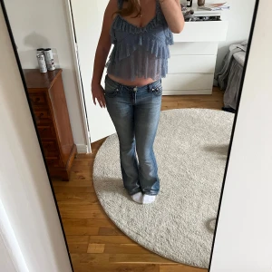 Blå spetsig linnetopp med volanger - Säljer en ljusblå linnetopp i spets med flera lager volanger. Endast använd 2 ggr