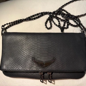 Svart axelväska från Zadig & Voltaire - Väska från Zadig & Voltaire Modell Rock Soft Savage Clutch  Ordinarie pris 5000