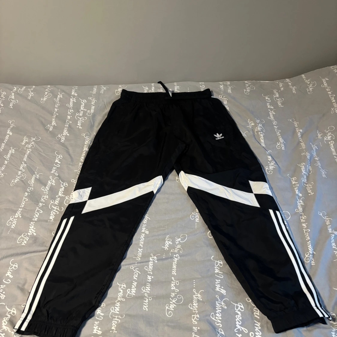 Svarta Adidas täckbyxor med vita detaljer