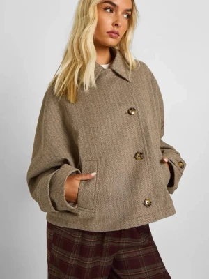 Beige rutig rock med knappar - Snygg beige rock i kort modell med rutigt fiskbensmönster. Jackan har stora knappar framtill och på ärmsluten, klassisk krage och två fickor. Oversized passform som ger en chill vibe. Perfekt för höst och vår när du vill vara både varm och stilren. Använd 1 gång då den var lite stor 
