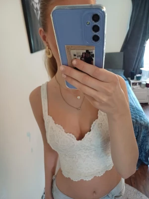 Vit spetsig linnetopp - Säljer en superfin vit linnetopp med breda axelband och vacker spetsdetalj. Toppen har v-ringning och är perfekt för fest eller nu till nyår. Skriv för frågor 