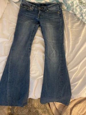 True Religion Joey Low Rise Flare Jeans - Säljer ett par blå True Religion Joey Low Rise Flare jeans,säljer pågrund av att de var för jag sydde dem för korta och har blivit längre de är i storlek 25 och är low Waist,jag skulle säga att om du är runt 155cm så kommer dessa passa perfekt.Personligen tycker jag de är så så fina och passar till allt dom är använda ca 8-10 gånger.❤️
