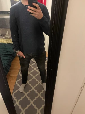 Mörkblå stickad tröja herr (Massimo Dutti) - Snygg mörkblå stickad tröja med rund hals och lång ärm. Enkel och stilren design som passar perfekt till jeans. Tröjan har en normal passform och är gjord i mjukt material som känns skönt mot huden.