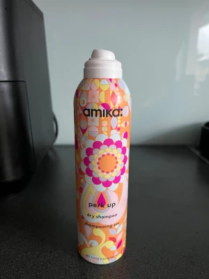 Amika Perk Up torrschampo 234 ml - Amika Perk Up torrschampo i en färgglad sprayflaska med retroinspirerat mönster. Innehåller 234 ml och är perfekt för att fräscha upp håret mellan tvättarna. Flaskan är orange, rosa och gul med blommiga detaljer och har en praktisk sprayfunktion.  Nypris ca 400kr. Helt oanvänd. Tyvärr har korken flygigt av och jag hittar den inte tyvärr