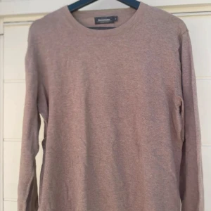 Beige långärmad tröja Dressmann M - Säljer en enkel och stilren beige långärmad tröja från Dressmann i Supima bomull. Tröjan har rund hals och en normal passform, perfekt för dig som gillar basic och mjuka material. Passar dig som vill ha en clean look.