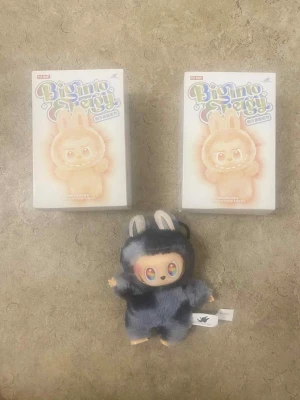 Mörkgrå pälsväst till figur - Säljer en fluffig mörkgrå pälsväst till samlarfiguren från Pop Mart Big Into Energy-serien. Västen har söta kaninöron och är gjord i mjuk syntetpäls som ger ett gulligt och lekfullt intryck. Perfekt för dig som gillar unika och kreativa accessoarer till dina figurer.