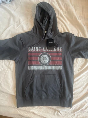 Saint Laurent hoodie - Säljer en otroligt snygg saint Laurent hoodie i nyskick. Tagsen är kvar. Storleken skulle jag säga är xs o passar om du är runt 170 o lite kortare