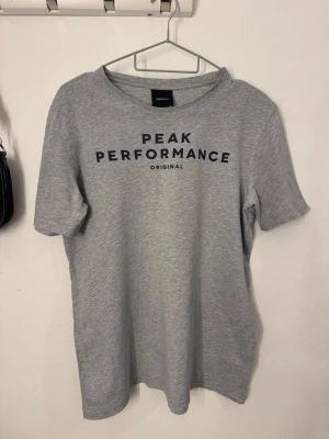 Peak Performance t-shirt - Säljer en grå t-shirt från Peak Performance. Tröjan är i storlek 170 (barnstorlek). Köpt för 250-300 kr. Fåtal gånger använd. Tröjan kan användas både av flickor och pojkar. 