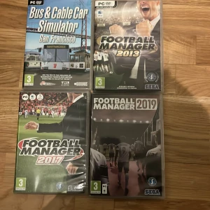 PC-spel: Football Manager 2013, 2017, 2019 & Bus & Cable Car Simulator - Fyra PC-spel i fint skick: Football Manager 2013, 2017 och 2019 från SEGA samt Bus & Cable Car Simulator San Francisco från Astragon. Alla fodral och skivor ser välbevarade ut, perfekt för dig som gillar sport- och simuleringsspel.
