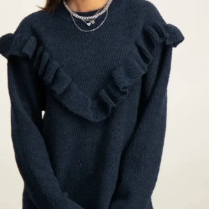 Mörkblå stickad volangtröja Gina Tricot - Mörkblå stickad tröja från Gina Tricot med snygga volangdetaljer i V-form över bröstet och axlarna. Tröjan har lång ärm och rund halsringning, perfekt för dig som gillar en trendig och mysig look.