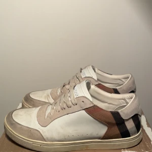 Burberry skor - Vita burberry skor. Har haft de ett tag och väljer nu att sälja de. De är helt skadefria och är fortfarande i ett godkänt skick. Lådan har defekter, man får med allt på bild och de. Skriv över funderingar och frågor. Priset är inte hugget i sten