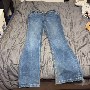 Blå bootcut jeans från Denim 1953 - Snygga lågmidjade jeans från Denim 1953 i klassisk bootcut-modell. Jeansen har normal passform och sitter bra runt midjan, dom är lite smutsiga ner till men kommer tvätta dom innan jag fraktar iväg 