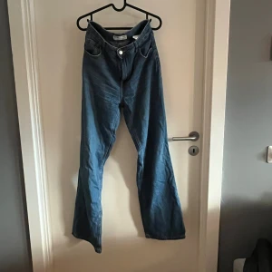 Blå wide jeans från Bershka - Säljer ett par blå jeans från Bershka i modellen '90s Wide'. De har hög midja, raka ben med bred passform och klassiska fem fickor. Jeansen är tillverkade i denim och har en snygg vintagekänsla med ljusblå tvätt.