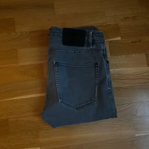 Neuw Jeans - Snygga grå jeans från Neuw med klassisk femficksdesign och svarta detaljer på bakfickan.  Perfekta för dig som gillar en stilren och enkel look. Modellen heter Lou Slim och är i storlek 31/32. Hör av dig vid funderingar! Mvh Carl