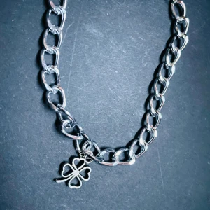By prisförslag- Silverfärgat armband med fyrklöver - Chunky armband i silverfärg med stora länkar och en söt fyrklöverberlock. Perfekt statement-piece för dig som gillar detaljer som sticker ut. Klöverhänget har hjärtformade blad och ger en cool och personlig touch till din stil.
